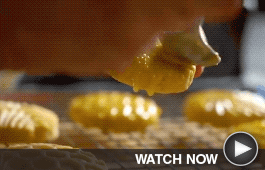 a baker glazes a holiday cookie