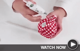 a crafter hot glues red gingham cloth on a christmas ornament