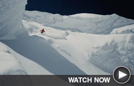 A skier sloughs through fresh powder on a mountain.