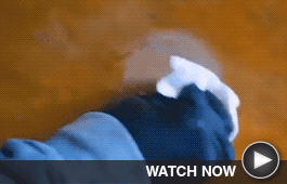 Close up of someone removing a stain from wood